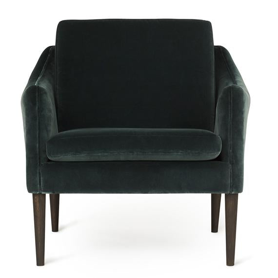 Emerald green velvet armchair with smooth upholstery and wooden legs, offering a modern, elegant design.
