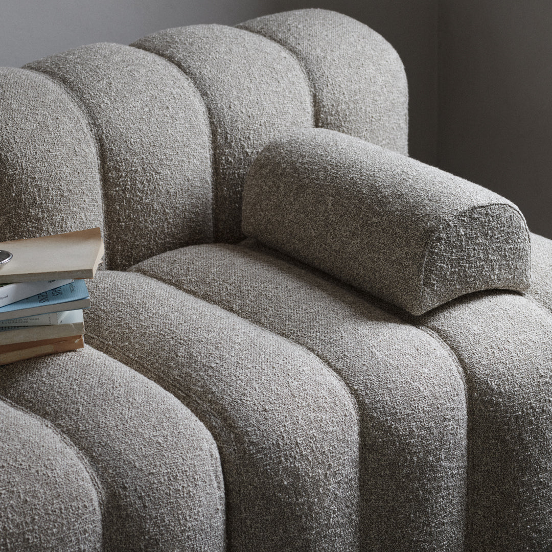 Textured beige fabric sofa with curved lines and a cozy, soft bolster cushion. Perfect for modern living spaces.