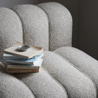 Textured beige upholstery on a curved chair, featuring soft, neutral tones with a hint of warmth.