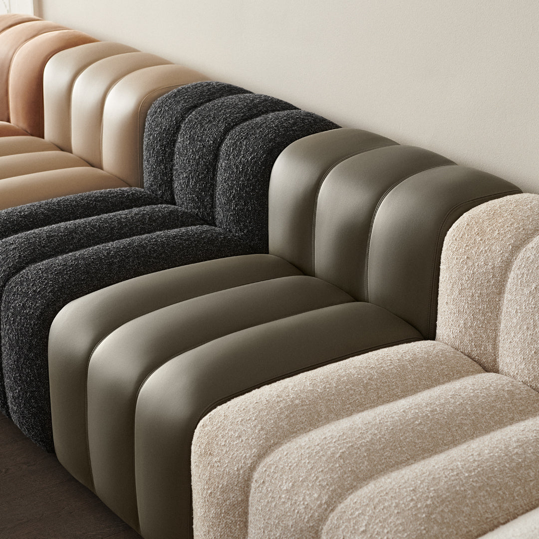 "Textured sofa in shades of beige, black, and olive green, featuring modern curved patterns."