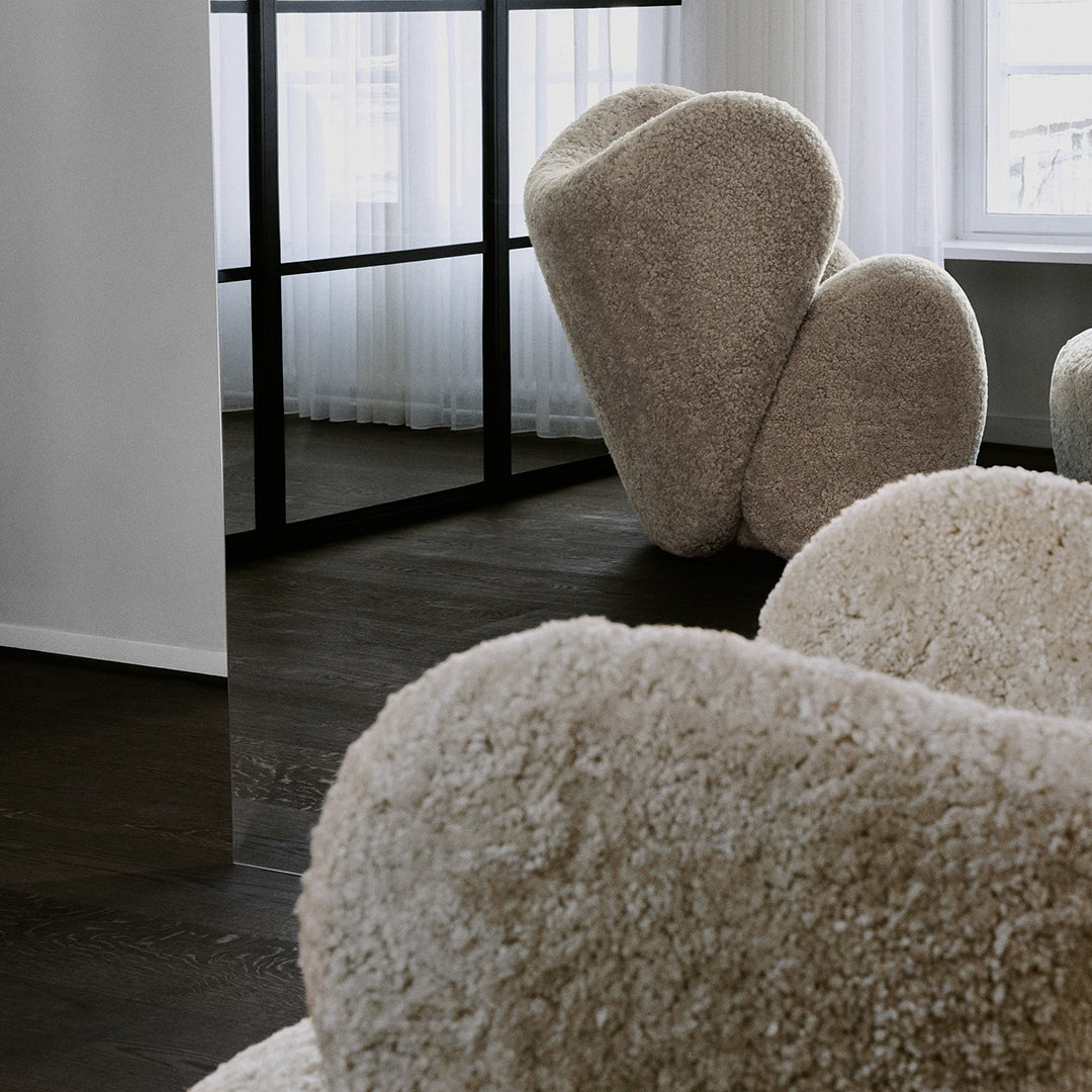 Cozy beige upholstered chairs with a textured, fluffy surface, set against a modern interior.