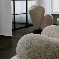 Cozy beige upholstered chairs with a textured, fluffy surface, set against a modern interior.
