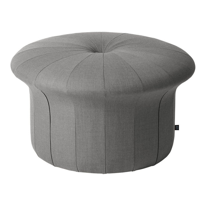 Gray upholstered round pouf with tufted top and vertical seam detailing, perfect for modern decor.