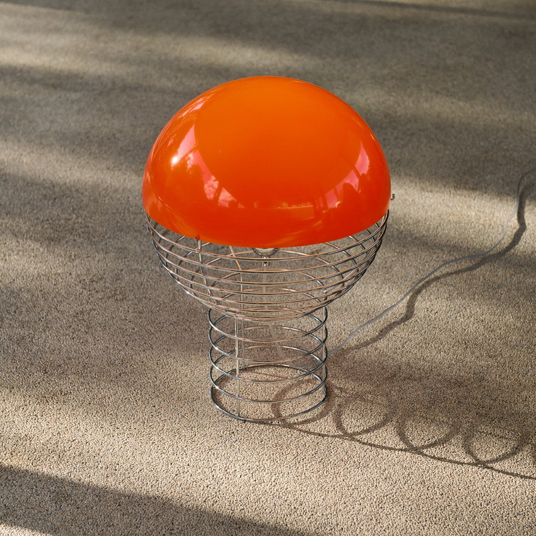 Orange dome-shaped lamp with a wire base, creating a modern and vibrant design. Ideal for contemporary decor.