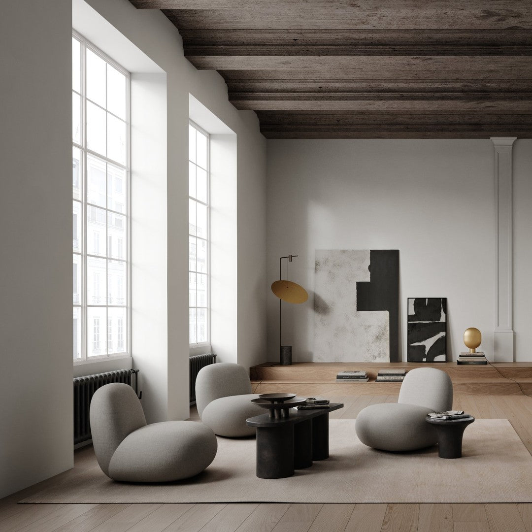 Modern living space with neutral gray furniture, warm wood accents, and black and white abstract art on walls.