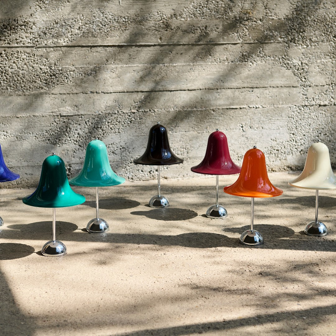 Colorful decorative bells in glossy green, blue, turquoise, black, red, orange, white, and purple, with chrome bases.