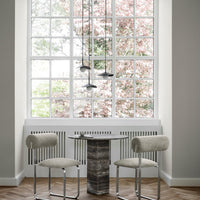 "Minimalist dining set featuring soft beige chairs and a textured gray table, set against a light-filled window backdrop."