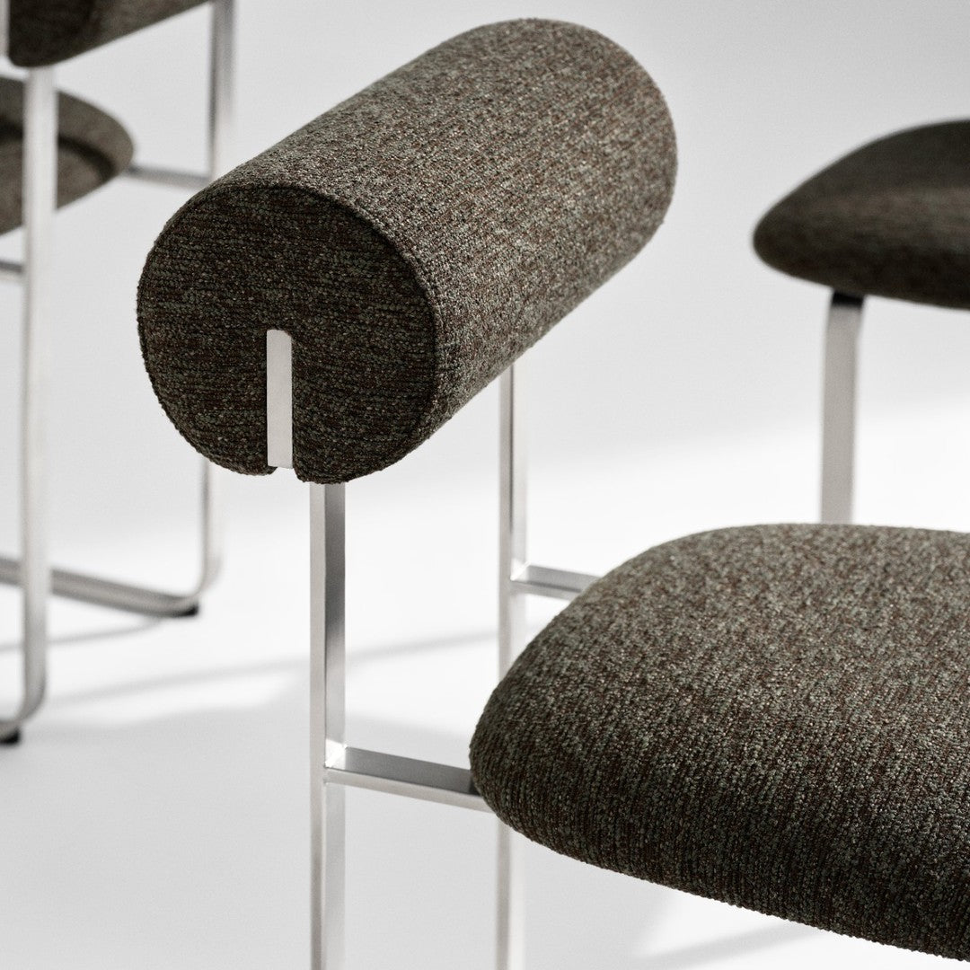 Brown textured upholstery with subtle grey and beige flecks on modern chair design.
