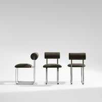 Set of three modern chairs featuring a sleek gray fabric with a subtle texture and chrome accents.