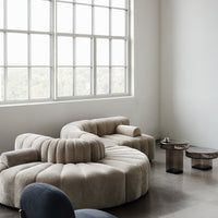 Beige, plush sectional sofa with rounded patterns; modern design enhances minimalistic decor.