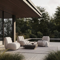 Soft beige lounge chairs with a textured pattern, surrounded by green foliage and a gray outdoor rug.