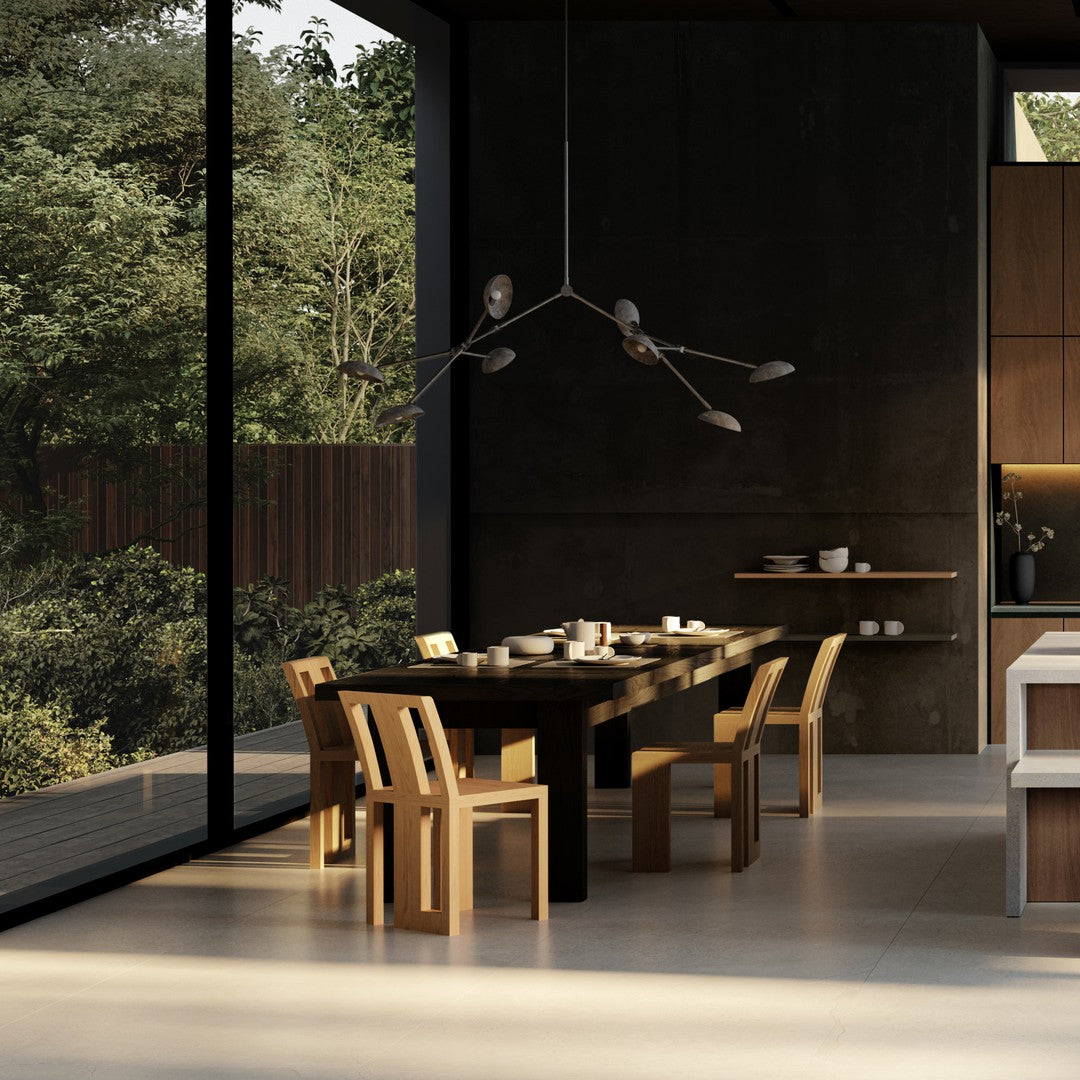 Modern dining room with dark wood table, light wooden chairs, and a neutral color palette against a green backdrop.