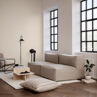 Light beige sectional sofa with textured fabric, paired with a minimalist cream rug and natural wood accents.