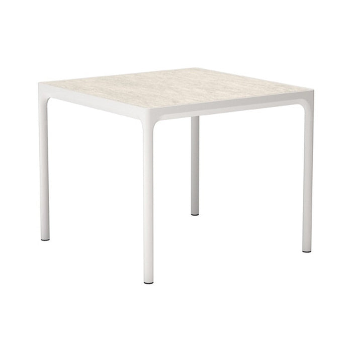 White square table with a textured cream surface and smooth white legs, perfect for modern decor.