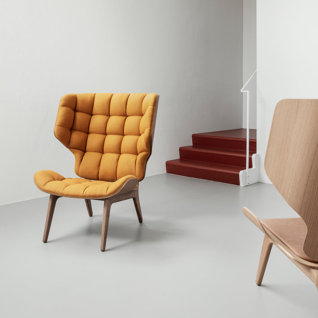 "Cozy tufted armchair in vibrant mustard yellow, featuring a modern design and natural wood legs against a minimalist backdrop."