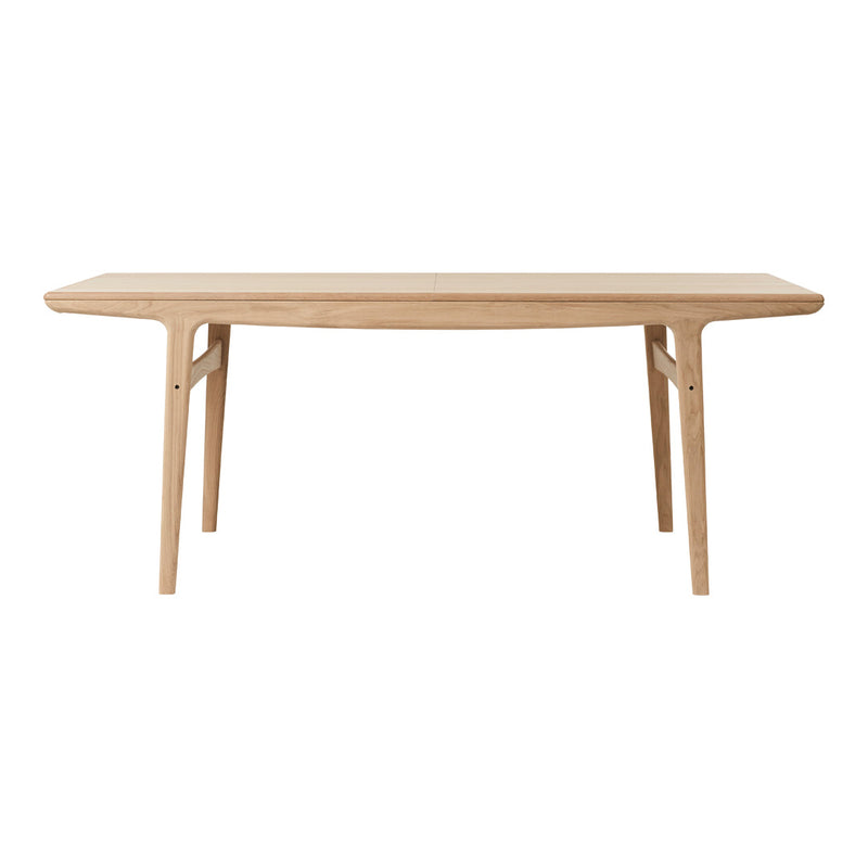 Light natural wood dining table with a smooth finish and minimalist design, featuring clean lines and no patterns.