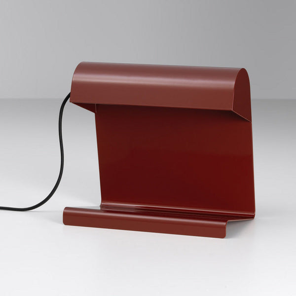Modern burgundy desk lamp with a sleek, minimalist design and a matte finish, featuring a smooth, curved silhouette.