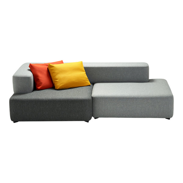 Gray sectional sofa with vibrant orange and yellow throw pillows, featuring a modern minimalist design.