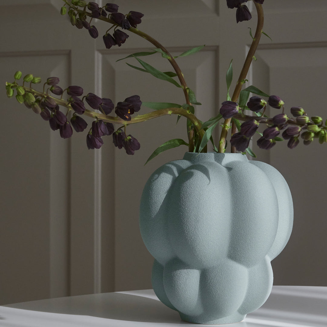 Light blue textured vase with a unique bulbous shape, showcasing elegant matte finish and soft shadows.