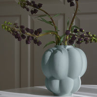 Light blue textured vase with a unique bulbous shape, showcasing elegant matte finish and soft shadows.