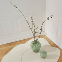 "Elegant green glass vases with a smooth, round shape, featuring subtle reflections and a minimalist design."