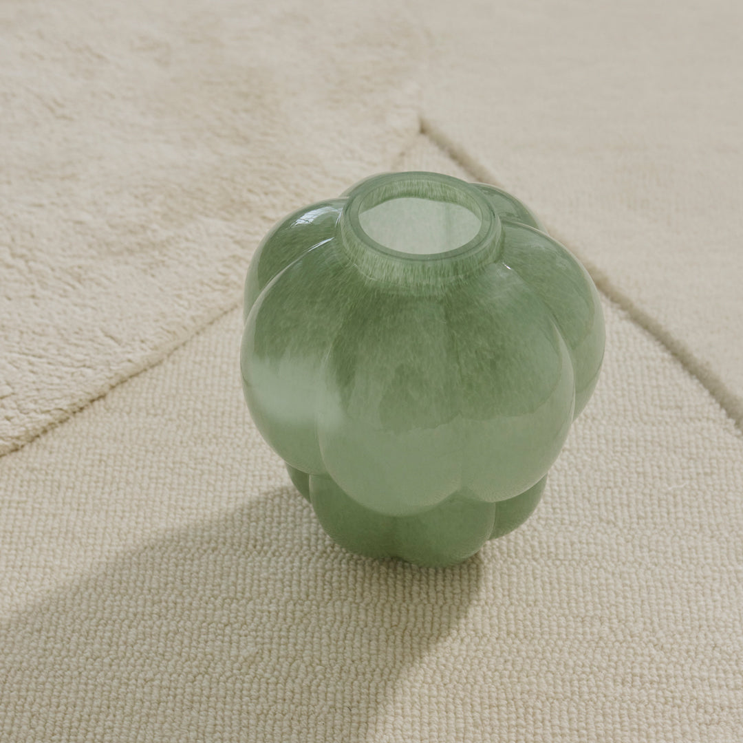 Green glass vase with a scalloped design, adding a stylish touch to any decor.