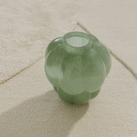 Green glass vase with a scalloped design, adding a stylish touch to any decor.