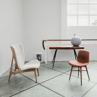 Modern chairs in white and brown, featuring minimalist design and unique textures, set against a neutral backdrop.