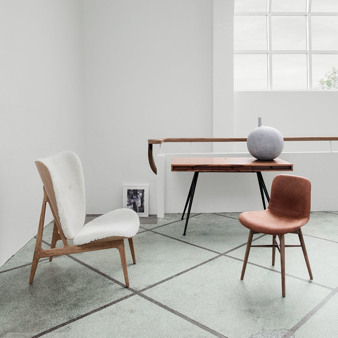 Modern chairs in white and brown, featuring minimalist design and unique textures, set against a neutral backdrop.