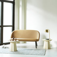 "Beige curved sofa paired with light wooden accent tables; soft gray rug enhances modern minimalist decor."