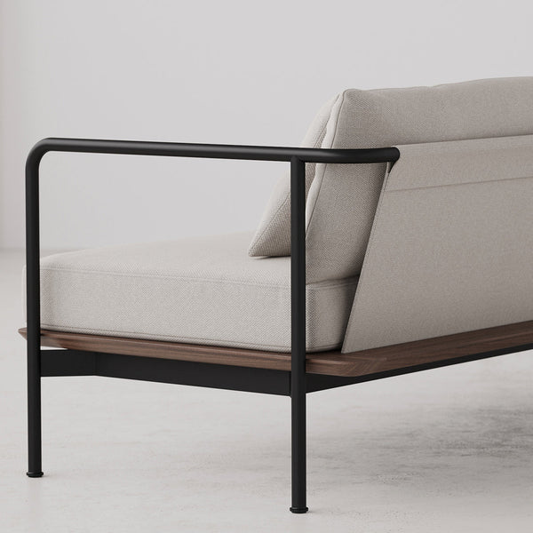 Light beige sofa with a sleek black metal frame and natural wood accent on a minimalist background.