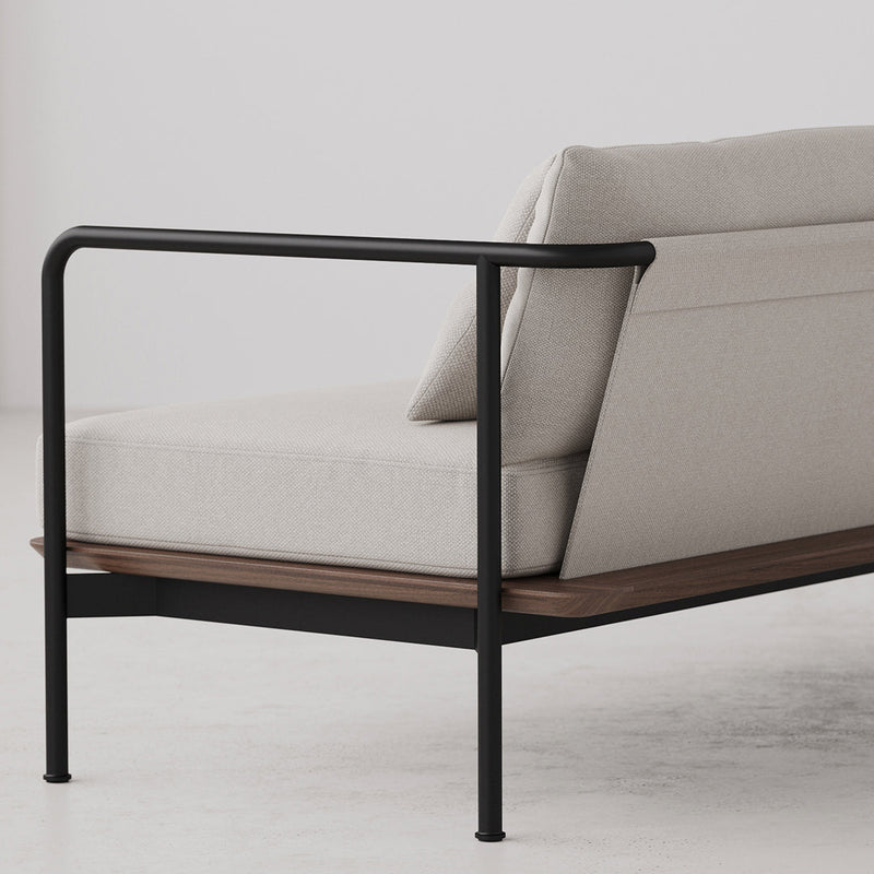 Light beige sofa with a sleek black metal frame and natural wood accent on a minimalist background.