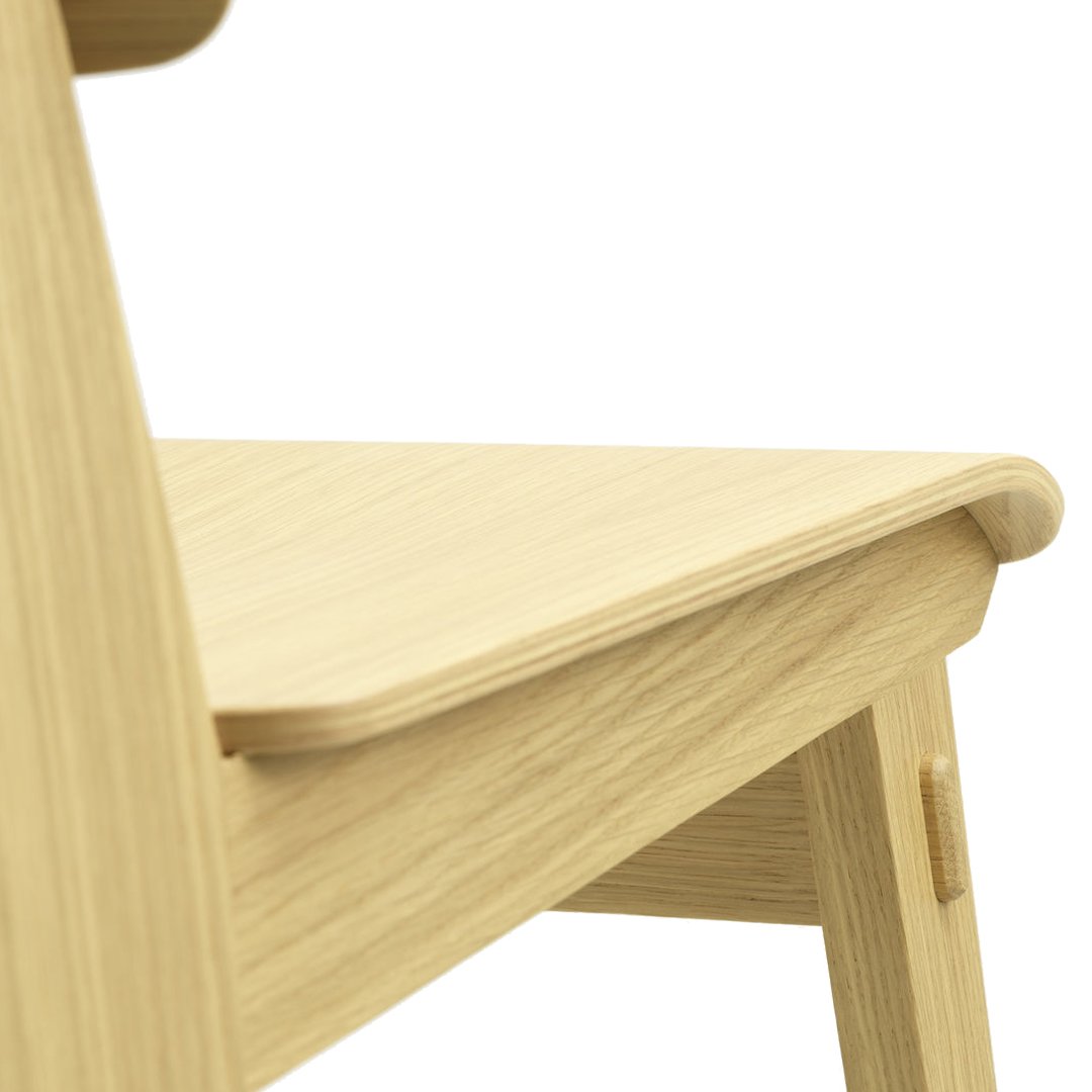 Light oak wood chair with smooth, natural grain pattern and minimalist design, featuring soft, rounded edges.
