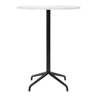 Round marble table with a sleek white top and minimalist black metal base, perfect for modern decor.