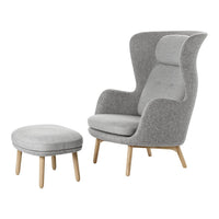 Gray upholstered armchair with matching ottoman, featuring smooth textures and minimalist design on wooden legs.