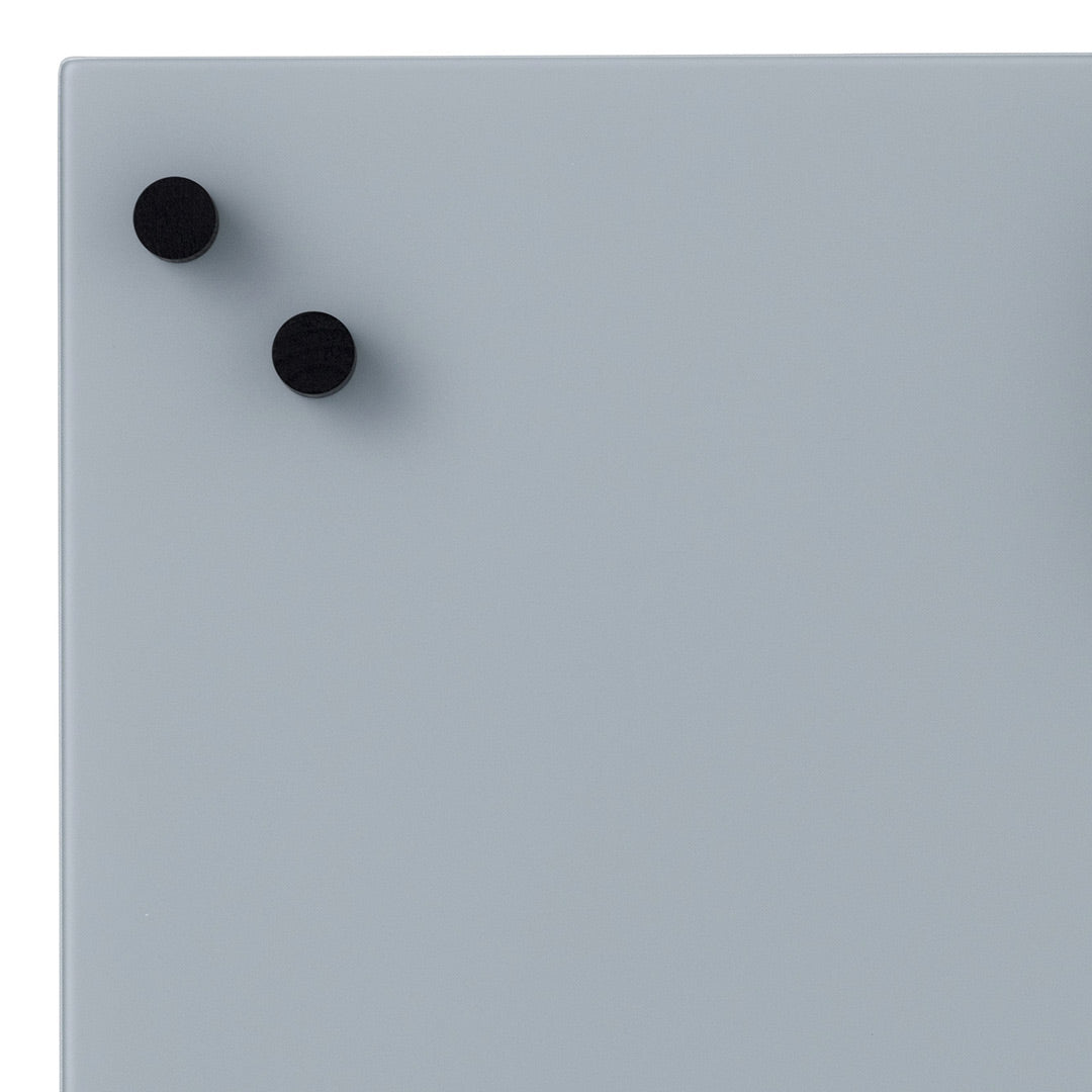 Light gray surface with two black round magnets, minimalistic design and smooth finish.