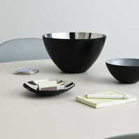 Black and metallic bowls on a neutral table, featuring sleek, modern designs and subtle color contrasts.