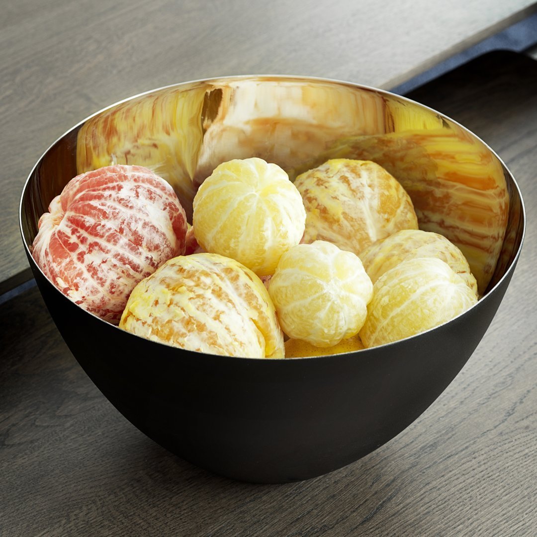Colorful assortment of textured citrus fruits in a sleek black bowl with a shiny gold interior.