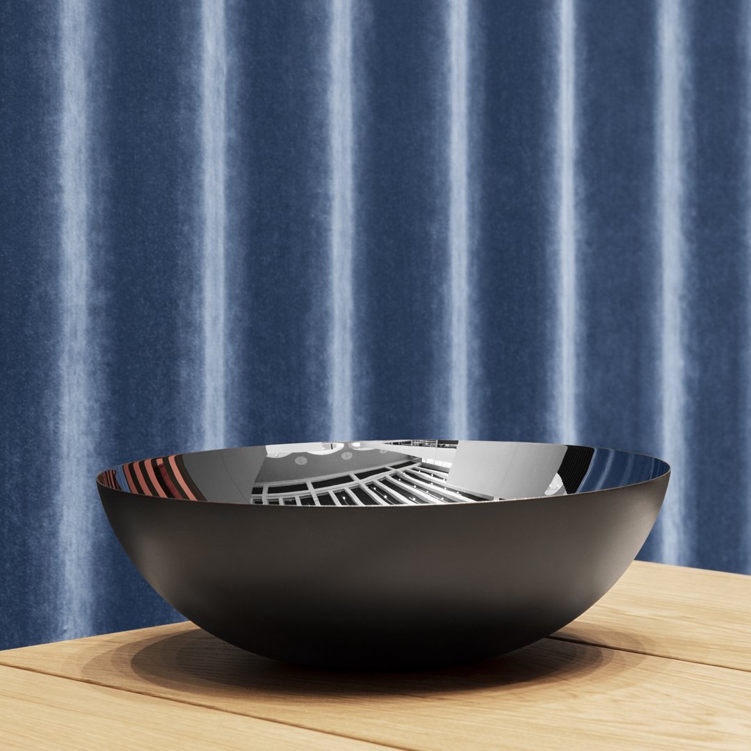 Black bowl featuring geometric patterns, placed on a wood surface, against a textured blue striped backdrop.