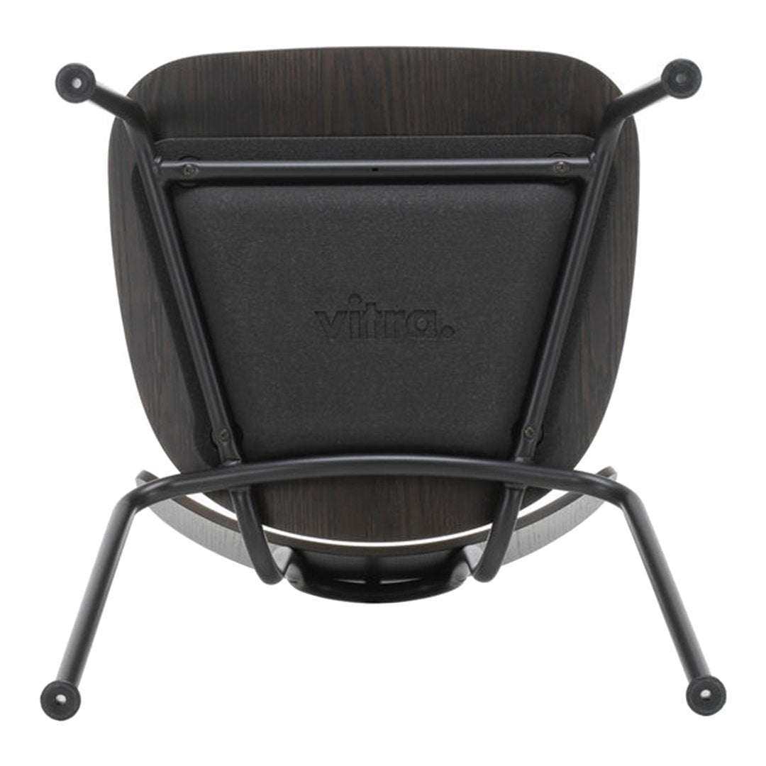 Black chair with a smooth, minimalist design, featuring a dark wood back and matte black metal legs.