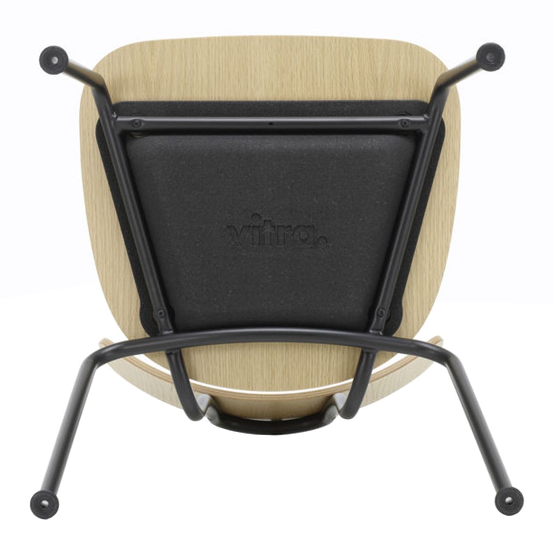 "Modern wooden chair with a natural finish, black seat cushion, and sleek black metal legs."