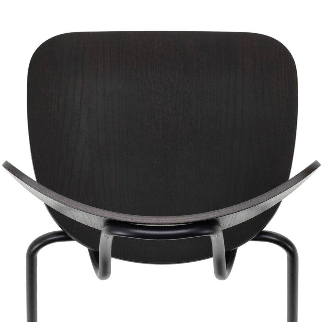 Sleek black chair back with smooth curves and subtle wood grain pattern, modern design aesthetics.