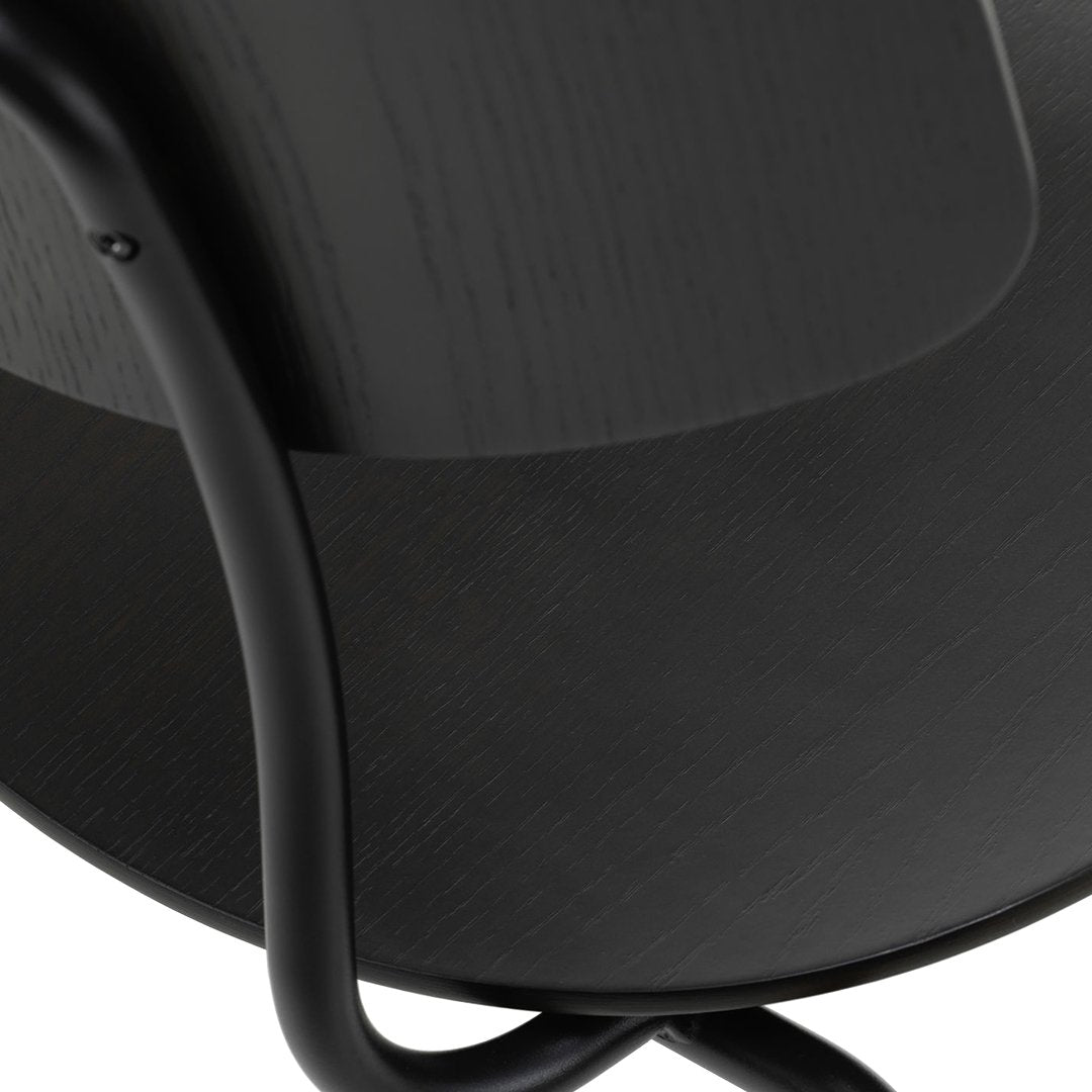 Black curved chair with a smooth matte finish and sleek black metal legs, featuring a subtle texture pattern.