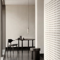 Modern black furniture with a minimalist design, set against a soft beige wall and patterned white accents.