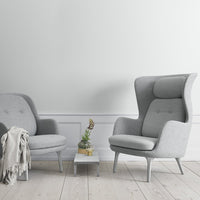 Gray upholstered chairs with smooth patterns, paired with a light wooden table and soft neutral tones in the background.