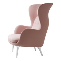 Pink upholstered armchair with a modern silhouette and white legs. Perfect for stylish home decor.
