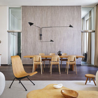 Stylish wooden dining set with sleek black lighting and a textured neutral wall, complementing warm tones and organic shapes.