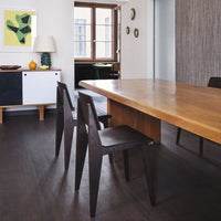 Modern wooden dining table with dark chairs, featuring a neutral color scheme and crisp, minimalist lines.