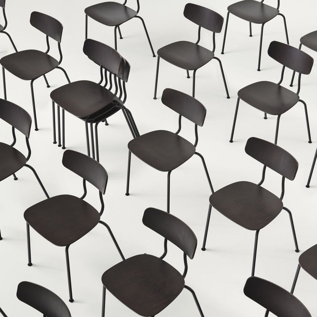 "Black metal chairs with smooth wooden seats, arranged in a modern pattern on a white background."