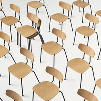 Minimalistic oak chairs with black metal legs, featuring a uniform arrangement on a white background.